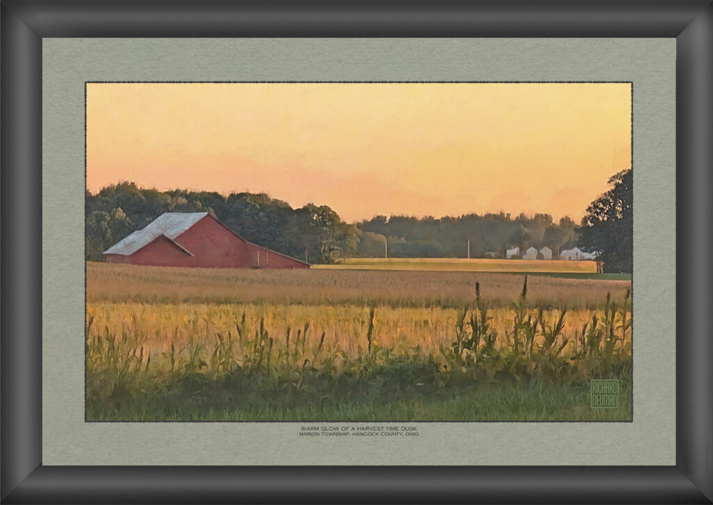 Red barn and harvested autumn fields glowing beneath a warm golden dusk sky